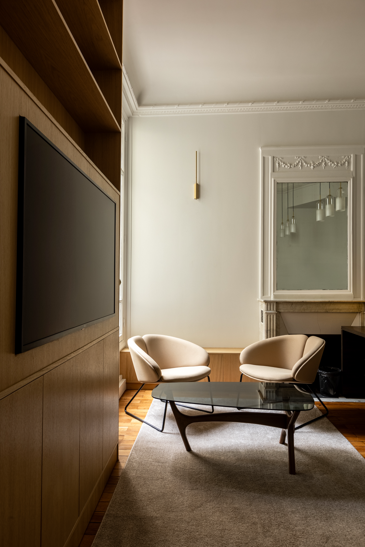 Salon avec fauteuils et téléviseur intégré dans un espace opéré par Volum